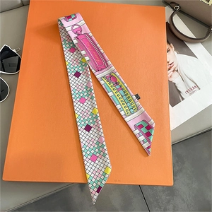 Macro shot of silk-style checkered scarf with France-Paris motif on orange gift box