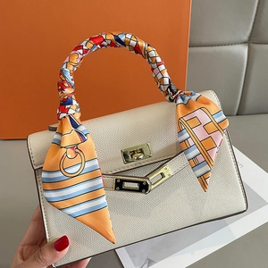 Litchi pattern cream leather handbag with geometric orange silk scarf on the handle