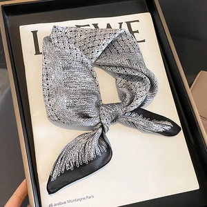 Foulard twilly en soie noir et blanc à motifs géométriques sur un magazine minimaliste