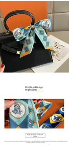 Detail of printed twilly silk scarf tied on black leather bag with geometric patterns