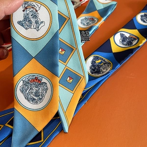 Detail of colorful twilly scarf featuring geometric patterns and dog illustrations