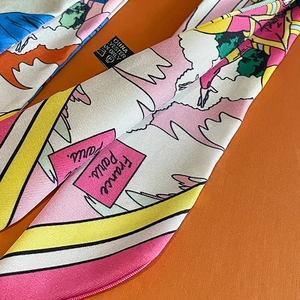 Vue macro du tissage sergé et de l'étiquette d'entretien d'un foulard en soie coloré