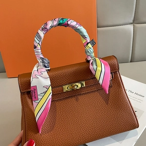 Sac à main en cuir marron avec poignée entourée d'un foulard et détails dorés