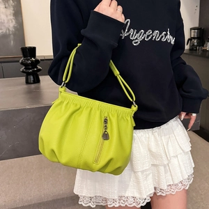 Neon green litchi leather pleated handbag with heart zipper detail shown on a model