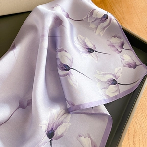 Détail d'un élégant foulard en soie violette avec motifs floraux et fini brillant