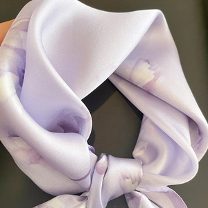 Vue macro d'un foulard en soie lilas avec imprimés floraux élégants et texture lisse