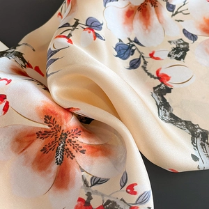 Elegant champagne silk scarf featuring red magnolia print with a luxurious satin texture