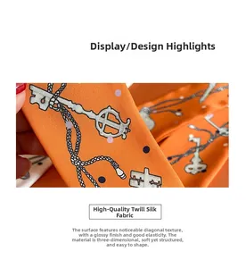 Detailed macro view of orange twill silk scarf with chain and key pattern texture