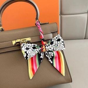 Braune Handtasche aus Leder mit gebundenem Seidentuch und goldener Schließe im Detail