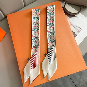 Floral skinny silk scarf twilly set on an orange gift box with striped patterns