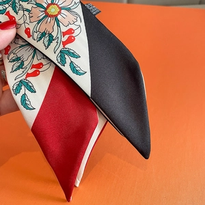 Close-up of a floral skinny scarf with geometric color blocks and hand-drawn patterns