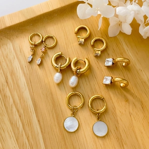 Boucles d'oreilles dorées avec perles d'eau douce et zircon carré sur plateau bois