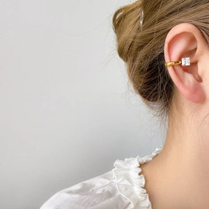 Manchette d'oreille dorée avec zircon carré et boucle d'oreille en perle sur modèle