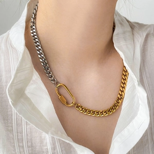 Macro view of gold and silver mixed Cuban chain with large lobster clasp on white shirt