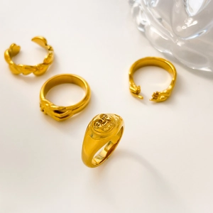 Details von 18K vergoldeten Ringen mit Sonnen- und Händedruck-Motiv auf weißem Grund