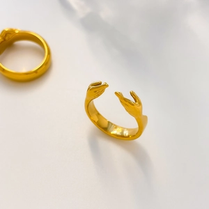 Detail eines 18K vergoldeten Titanrings mit einzigartigem Händedesign und offener Ringschiene