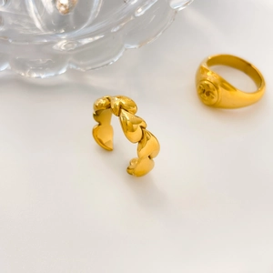 Makroaufnahme des 18K vergoldeten Herzkettenrings und Siegelrings mit Relief
