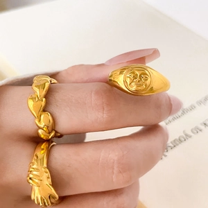 Detaillierte Ansicht von drei vergoldeten 18K Titanstahlringen, getragen an einer Hand