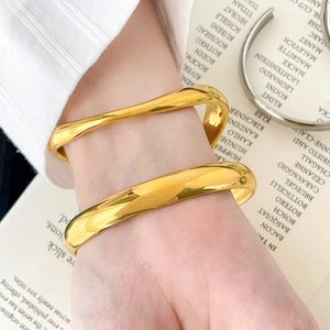 Chic gold stainless steel wave bangle and thick open cuff set on a wrist