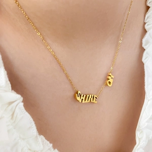 Détail du collier en titane plaqué or 18K avec pendentifs SHINE ON sur un mannequin femme