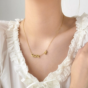 Détail d'un collier en acier titane doré avec pendentif SHINE ON sur cou de mannequin