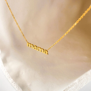 Dettaglio macro della collana con ciondolo a lettere MAMA placcata in oro 18 carati