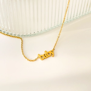 Dettaglio di una collana con ciondolo baby placcata oro su vetro a righe lucido