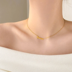 Dettaglio del ciondolo Forever dorato con catena sottile indossato sul collo