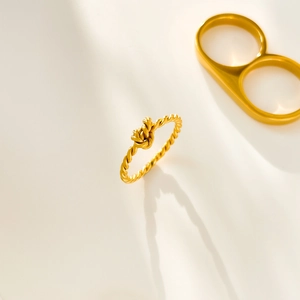 Detailed shot of 18K gold plated titanium ring with twisted rope design and elegant knot