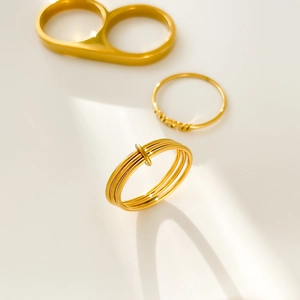 Detailed view of three-piece 18K gold plated stackable rings with LOVE engraving and twist design