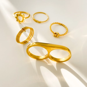 Detailed set of five 18K gold-plated rings including sunflower and mama twist designs