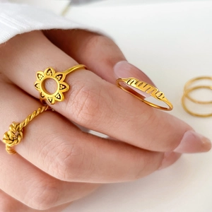 Macro view of gold 18k plated rings set with mama lettering and sunflower designs