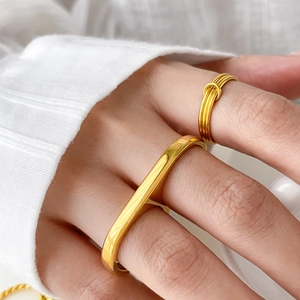 Close-up of 18K gold plated double finger ring and triple twist knot design on hand