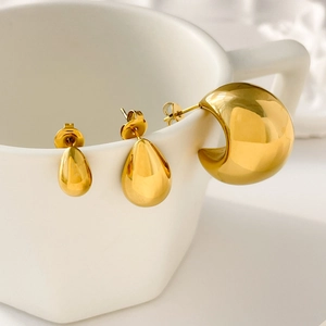 Detail of hollow geometric moon and waterdrop studs on a white ceramic mug edge