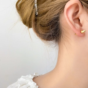 Orecchini a perno conici placcati in oro 18 carati indossati da una modella