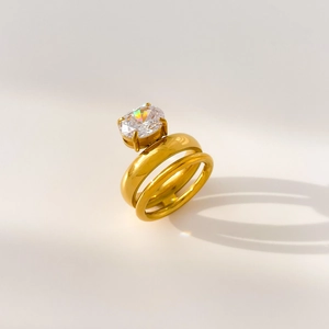 Detailed view of polished titanium steel rings featuring large oval zircon and gold finish