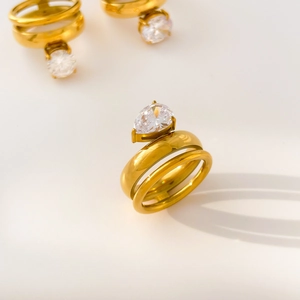Detail of gold-plated titanium steel rings with pear-shaped and round white zircons