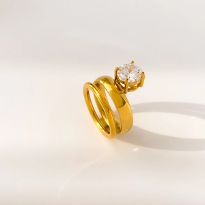 Macro detail of golden double-layer ring featuring a brilliant round-cut cubic zirconia
