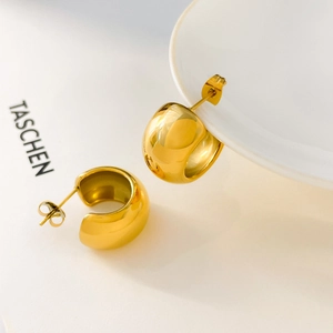 Detail of 18K gold plated C-shaped chunky hoop earrings with mirror polished finish