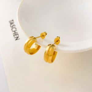 Detailed macro shot of C-shaped drop earrings in 18K gold-plated stainless steel