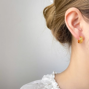 Classic 18K gold plated stainless steel C-shape hoop earrings worn by a female model