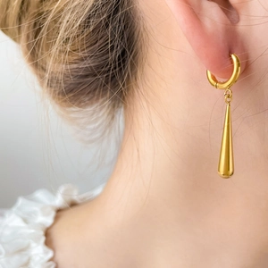 18K gold plated titanium C-shape drop earrings worn by a model in a studio close-up