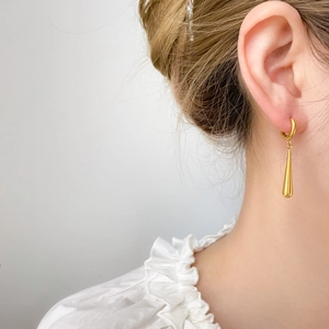Detail of 18K gold plated teardrop hoop earrings worn showing mirror polish and elegant design