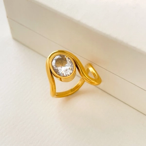 Macro shot of 18K gold plated stainless steel ring with oval zircon in a wave design