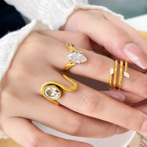 Close-up of three gold-plated titanium steel rings with marquise and round zircons