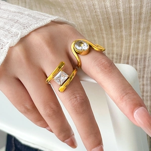 Detailed view of two 18K gold plated titanium rings with square and round zircon stones
