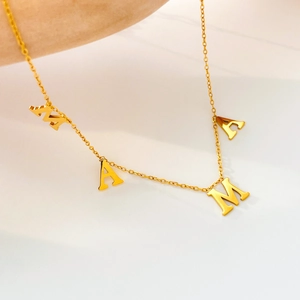Vue macro du collier avec pendentif lettres MAMA plaqué or 18 carats au fini poli