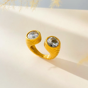 Macro detail of gold-plated snake-style ring featuring dual zircon stones and ribbed texture