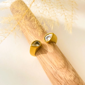 Close-up of 18K gold plated snake ring with double zircon teardrops on wood stand