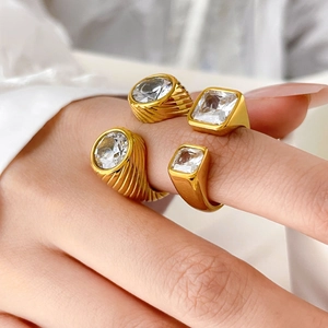 Detail of four-piece stackable gold plated rings with cubic zirconia on female finger